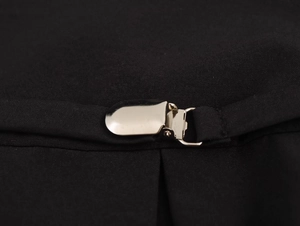 Gros plan sur la boucle métallique argentée et la texture de la maille noire sur la robe