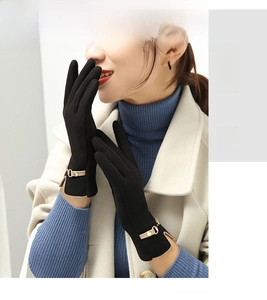 Detail of black winter glove with leather strap, gold buckle and side slit design