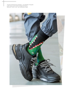 Detailed view of green cotton crew socks featuring a creative cartoon dinosaur pattern
