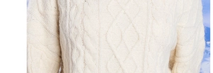 Detail of cream cable-knit pattern and soft fleece lining on a winter thermal hat