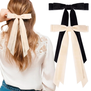 Velvet hair clips with long ribbons in black and beige shown on a model hair style