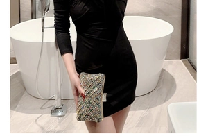 Macro detail of luxury rectangular evening clutch bag with colorful rhinestones on black dress