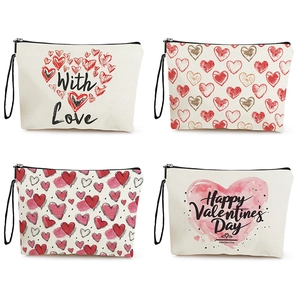 Set of four beige canvas makeup bags with red heart patterns and black wrist straps
