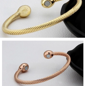 Detailed macro of magnetic cable twist bangles in gold and rose gold finishes
