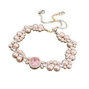 Elegant pearl bracelet with a large pink oval gemstone and adjustable drawstring chain