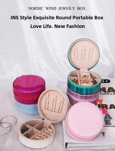Detail view of round portable jewelry box with interior hooks and ring slots