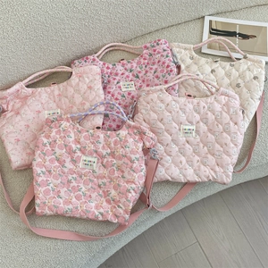 Gros plan de sacs matelassés multicolores sur un canapé avec bandoulières réglables