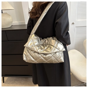Detailed view of silver quilted shoulder bag with padded rhombic pattern and metallic finish