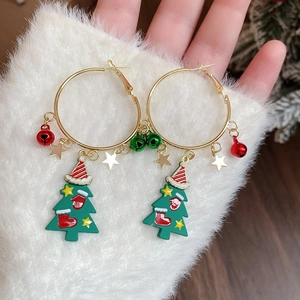 Close-up of festive Christmas hoop earrings with colorful holiday charms and bells