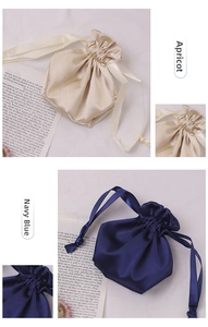 Detail of satin drawstring bags in apricot and navy blue with elegant pleated closure