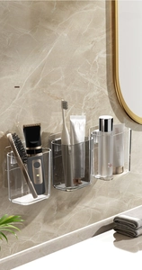 Wall-mounted clear bathroom organizer set storing electric razor and skincare products