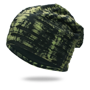 Close-up of green tie-dye knit beanie with distressed rip details and soft inner lining