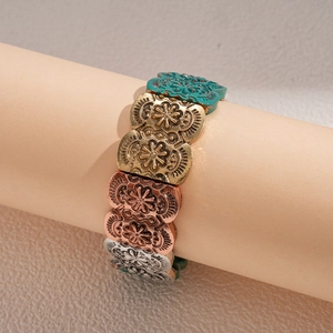 Detailed macro view of vintage embossed floral patterns on the multi-color mixed metal bracelet