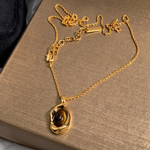 Gold-plated necklace featuring oval brown tiger eye pendant on a twisted chain