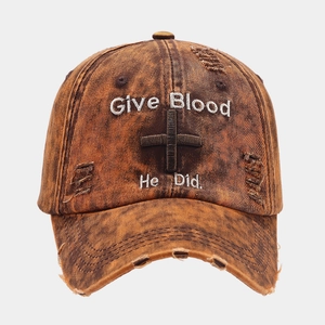 Close-up of vintage washed baseball cap with cross embroidery and distressed hole details