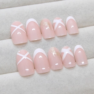 Elegant French press-on nails with light pink base, white cross patterns and gold glitters