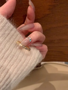 Detail of a gold S925 silver ring featuring a bow knot with mother of pearl and zircons
