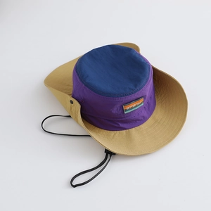 Detail of color-block sun hat showing wide khaki brim and adjustable windproof cord