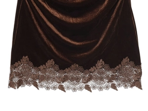 Détail de la texture en velours et de la dentelle élégante sur l'ourlet de la robe