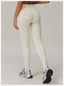 Rear view of high waisted cream yoga pants showing body-sculpting seam and elastic fabric