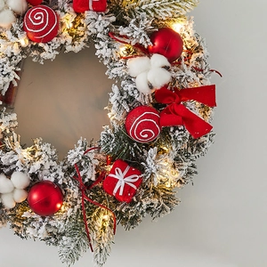 LED lighted Christmas wreath with snow flocking, red ornaments, cotton and ribbons