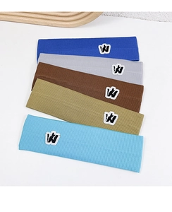 Detail showing five ribbed knit sports headbands in blue grey and brown with W logo patch
