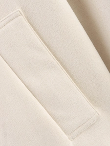 Gros plan détaillé du tissu en daim beige avec coutures de haute qualité sur la veste