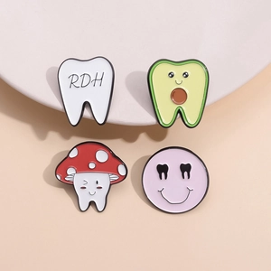 Cartoon dental enamel pin set featuring cute teeth and RDH designs on white plate