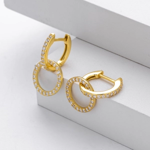 Macro shot of gold-plated double hoop earrings featuring pavé-set sparkling cubic zirconia