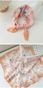 Detail of floral linen-cotton square scarf showing pink-orange pattern and soft texture