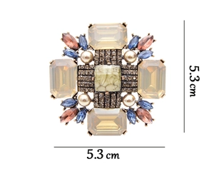 Detailed close-up of retro geometric brooch with rhinestones and turquoise stone inlay