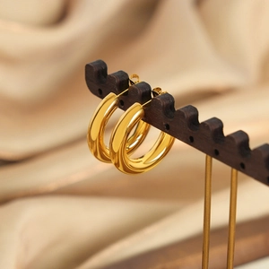 Elegant gold-plated titanium steel C-shaped hoop earrings on a black display stand
