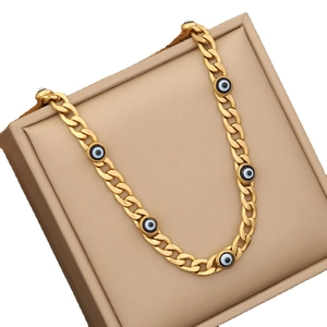 Gold stainless steel Cuban chain necklace with multiple blue evil eye charms on stand