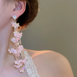 Close-up of pink flower petal tassel earrings with rhinestones on model for beach style