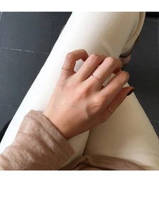 Detailed view of stacked minimalist rose gold thin bands on model fingers