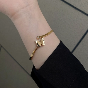 Polished 18k gold butterfly open bangle with frosted finish wings and zircon accent
