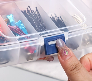 Detailansicht zum Öffnen der transparenten Haarschmuckbox mit blauem Verschluss