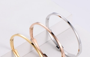 Close-up of minimalist titanium steel bangles with rectangular clasp and rhinestone detail