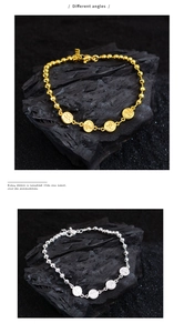 Close-up of gold and silver beaded bracelets with engraved charms on dark stones