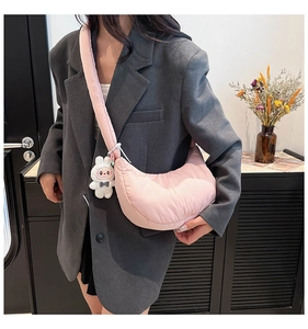 Detailed view of pink dumpling crossbody bag with cute white bunny plush charm
