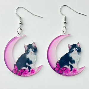 Pink crescent moon acrylic earrings featuring black and white cat and flower patterns