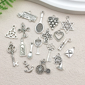 Macro view of assorted antique silver alloy charms including school bus and cross symbols