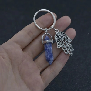 Detail showing Hamsa Hand pendant and blue natural crystal pillar on silver keychain