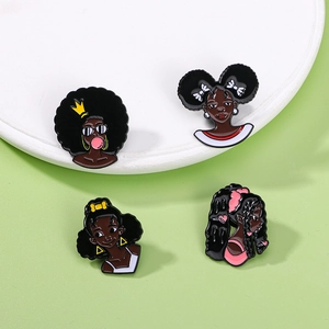 Enamel pins featuring diverse black girl cartoon characters on a white display tray