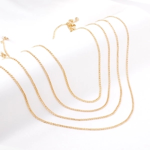Elegante mehrlagige 2,3mm goldene Edelstahl-Panzerkette auf weißem Stoffhintergrund