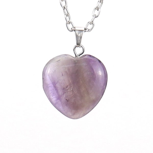 Detailed close-up of a faceted heart-shaped purple natural stone pendant with silver chain
