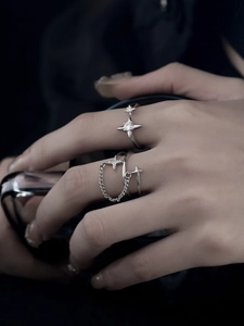 Detail of adjustable silver-tone star rings with sparkling crystals on a model's hand