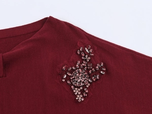 Detailed view of burgundy knitwear with exquisite handmade bead flower embroidery work