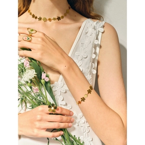 Model trägt Gold-Gänseblümchen-Set mit Halskette, Armband und Blumenringen aus Harz