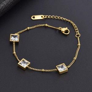 Detailed view of a gold titanium steel bracelet with square clear crystals on black leather